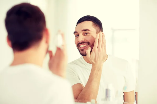 Homem feliz aplicando espuma de barbear no espelho do banheiro — Fotografia de Stock