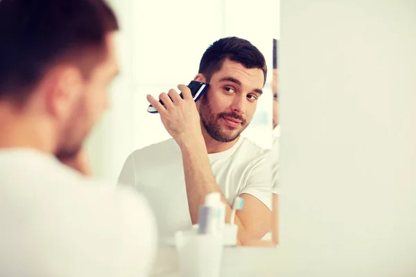 Człowiek do golenia brody z obcinaniem w łazience — Zdjęcie stockowe