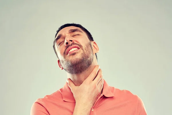 Mężczyzna dotyka szyi i cierpiących na ból gardła — Zdjęcie stockowe