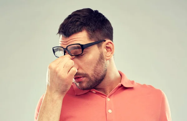 Unavený muž s brýlemi dotýká nosu — Stock fotografie