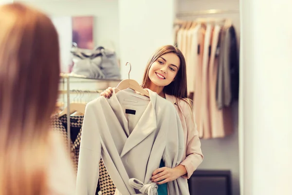 Boldog asszony kipróbálás kabát ruha tárolására tükör — Stock Fotó