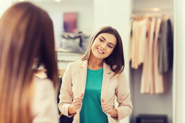 Donna felice posa allo specchio nel negozio di abbigliamento — Foto Stock