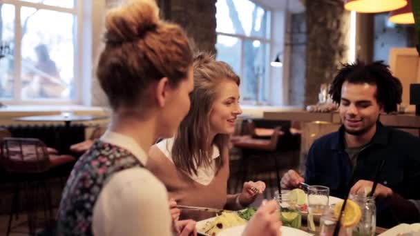Amigos felices comiendo y bebiendo en el restaurante — Vídeo de stock