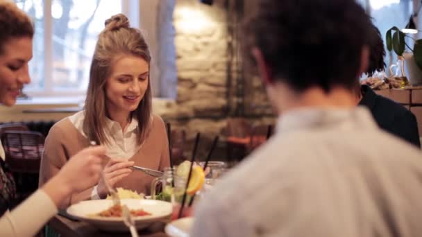 Amigos felices comiendo y bebiendo en el restaurante — Vídeo de stock