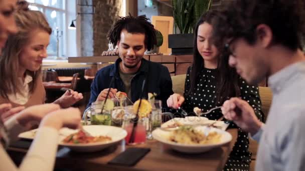 Amigos felices comiendo y bebiendo en el restaurante — Vídeos de Stock