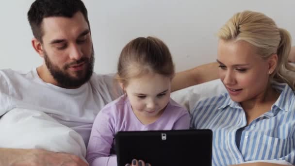 Ευτυχισμένη οικογένεια με tablet pc στο κρεβάτι στο σπίτι — Αρχείο Βίντεο