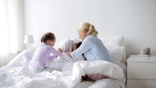 Счастливая семья, весело проводящая время в постели дома — стоковое видео