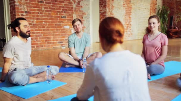 Группа людей, отдыхающих на ковриках для йоги в спортзале — стоковое видео