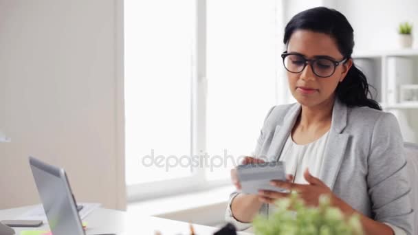 Businesswoman with calculator counting at office — Stock Video