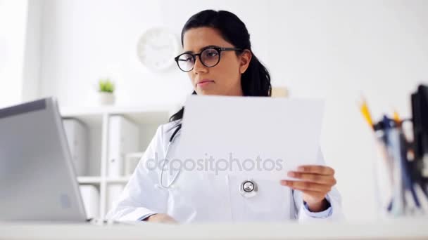 Médico feminino com laptop e papéis no hospital — Vídeo de Stock