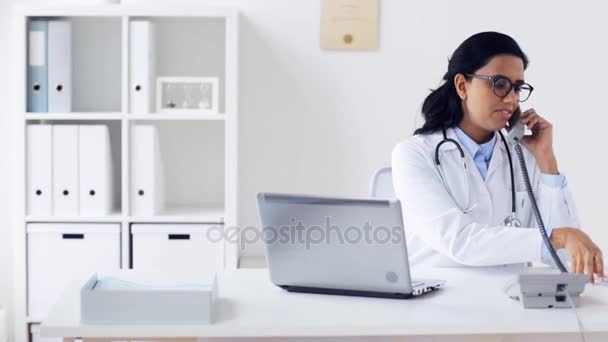 Läkare med papper som ringer på telefonen på sjukhus — Stockvideo