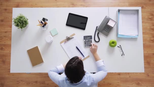 Femme d'affaires avec papiers et calculatrice au bureau — Video