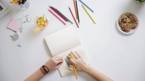 自宅の机でノートに絵を描く女性 — ストック動画