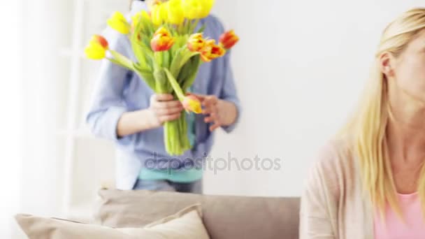 Boldog lány ad virágot anyának otthon — Stock videók