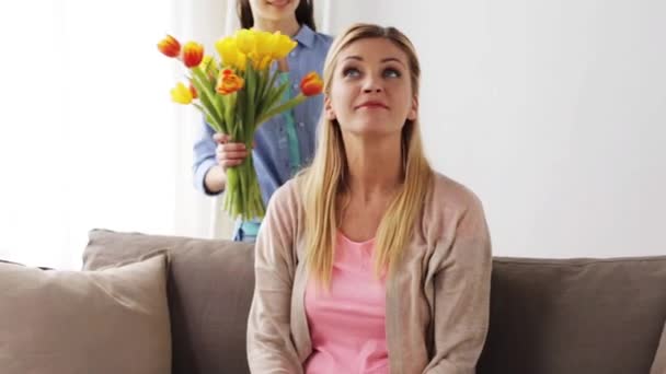 Feliz chica dando flores a la madre en casa — Vídeos de Stock