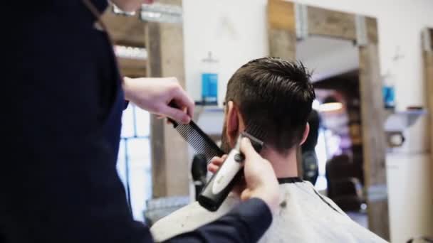 Homem e estilista fazendo corte de cabelo na barbearia — Vídeo de Stock