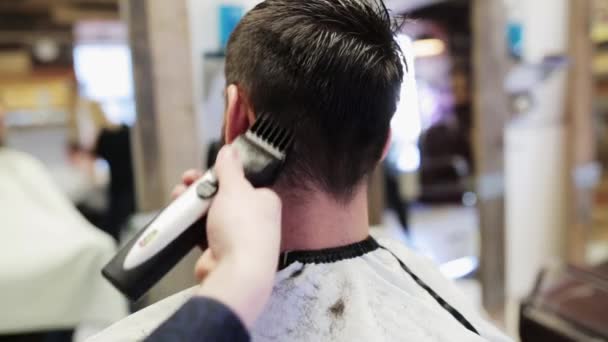 Homem e estilista fazendo corte de cabelo na barbearia — Vídeo de Stock