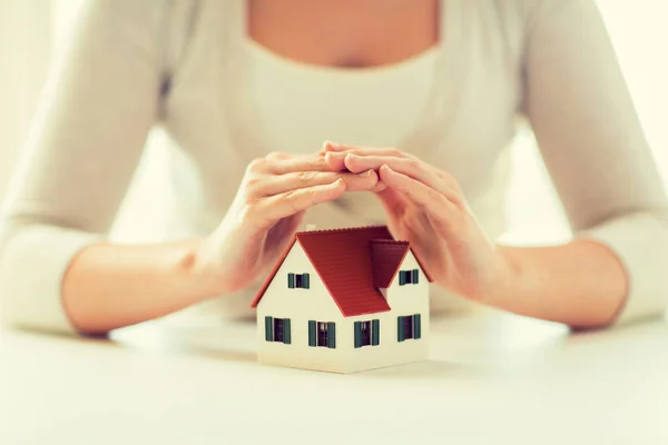 Close up of hands protecting house or home model — Stock Photo, Image