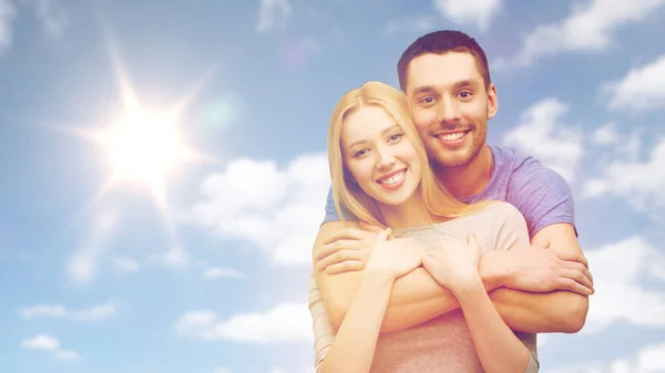 Szczęśliwy uśmiechający się para przytulanie przez niebo i słońce — Zdjęcie stockowe