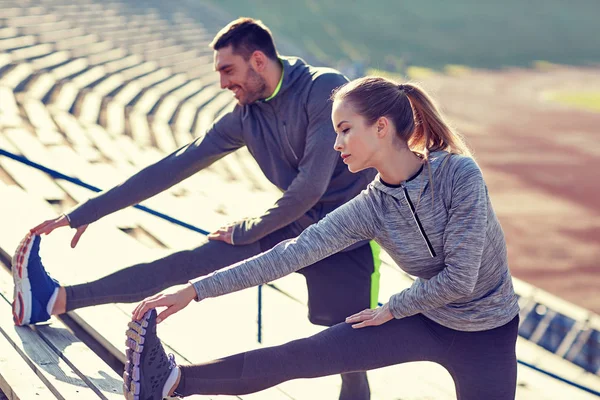 Para stretching nóg na trybunach stadionu — Zdjęcie stockowe