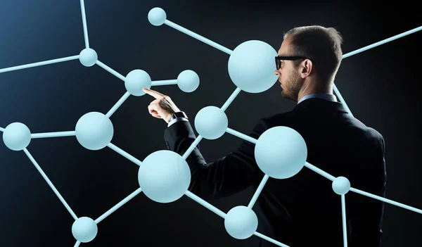 Бизнесмен указывает пальцем на виртуальную молекулу — стоковое фото