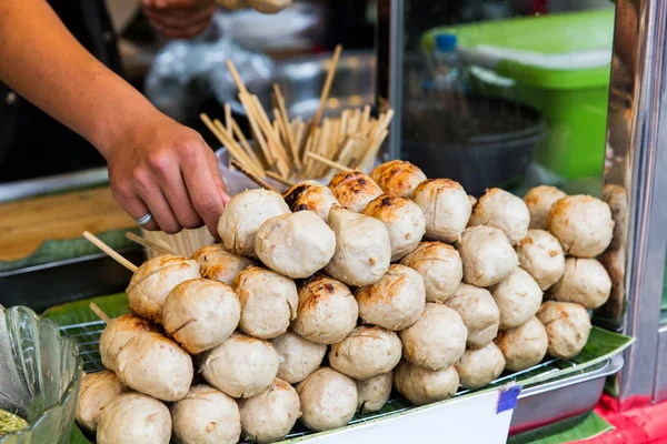 Mano del vendedor con albóndigas en el mercado callejero — Foto de Stock