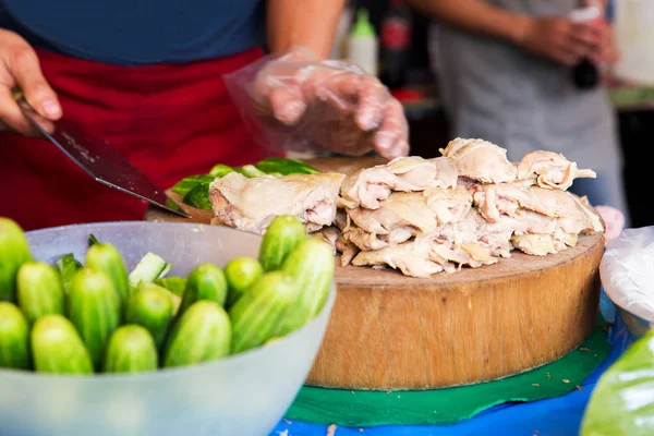 Cook with poultry and cucumbers at street market — Stock Photo, Image