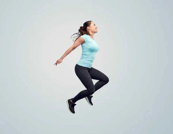 Gelukkig glimlachen sportieve jonge vrouw springen in de lucht — Stockfoto