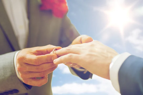 Close up de masculino gay casal mãos e anel de casamento — Fotografia de Stock