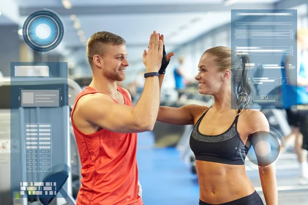 Smiling man and woman doing high five in gym — Stock Photo, Image