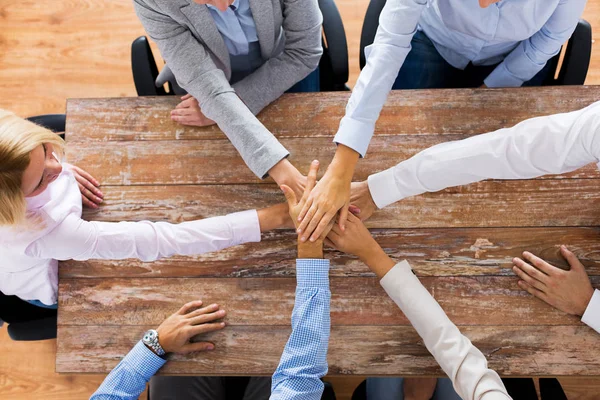 Affärsmän som håller händerna vid office bord — Stockfoto