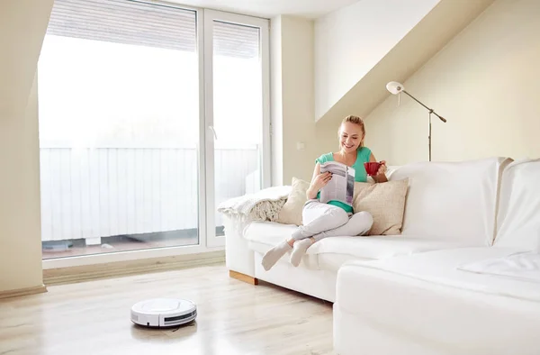 Mujer feliz y robot aspiradora en casa —  Fotos de Stock