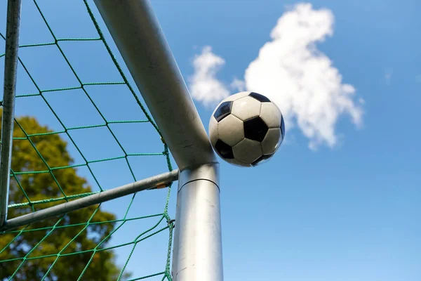 Bola de futebol voando em futebol gol net sobre o céu — Fotografia de Stock