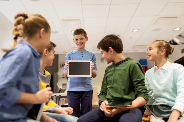 Grupa szczęśliwych dzieci z tabletem w szkole — Zdjęcie stockowe