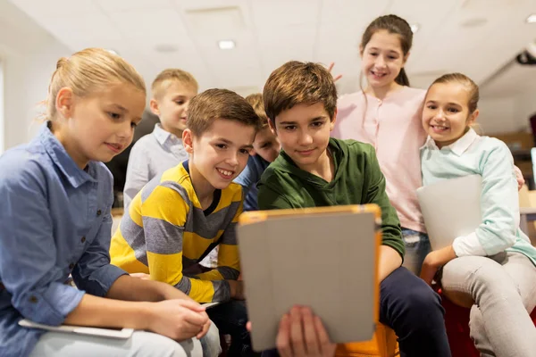 Group of happy children with tablet pc at school — Stock Photo, Image