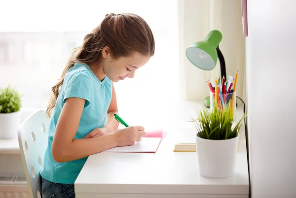 Heureux fille écriture pour ordinateur portable à la maison — Photo