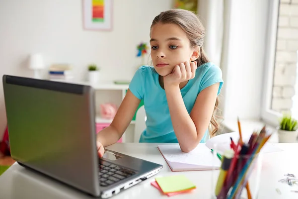 Gelangweiltes Mädchen mit Laptop und Notebook zu Hause — Stockfoto