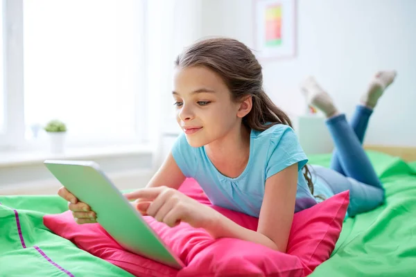 Uśmiechnięte dziewczyny z komputera typu tablet, leżąc w łóżku w domu — Zdjęcie stockowe