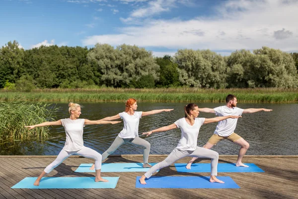 Grupo de personas haciendo ejercicios de yoga al aire libre Imagen de archivo