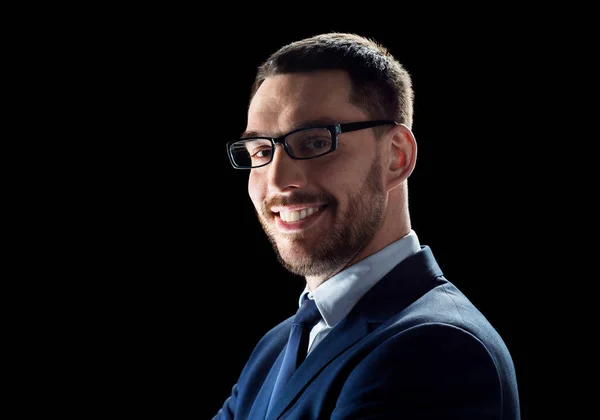 Lächelnder Geschäftsmann mit Brille über Schwarz — Stockfoto