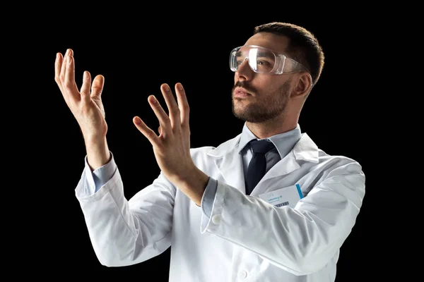 Médico o científico con bata de laboratorio y gafas de seguridad — Foto de Stock