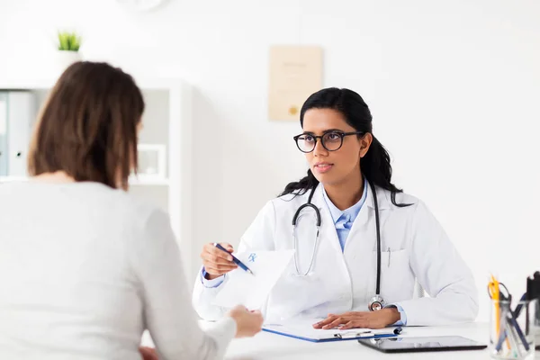 Médico con portapapeles y mujer en el hospital — Foto de Stock