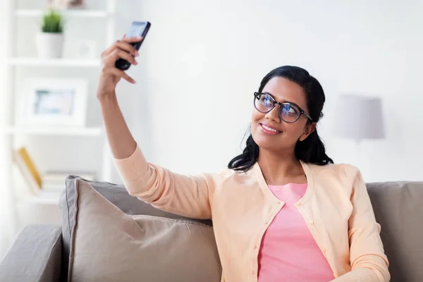 Щаслива жінка бере селфі зі смартфоном вдома — стокове фото