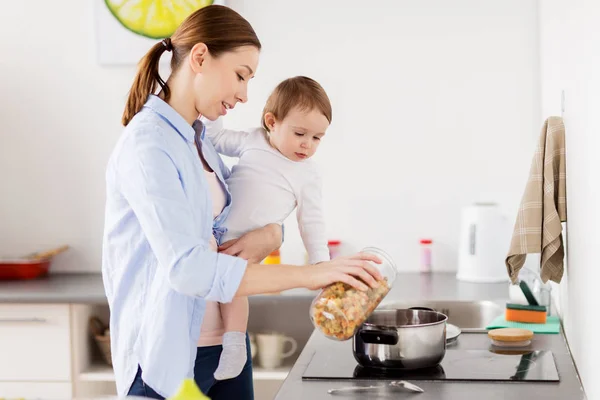 Madre y bebé cocinando pasta en la cocina casera —  Fotos de Stock