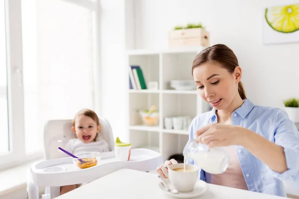 Mãe feliz e bebê tomando café da manhã em casa — Fotografia de Stock