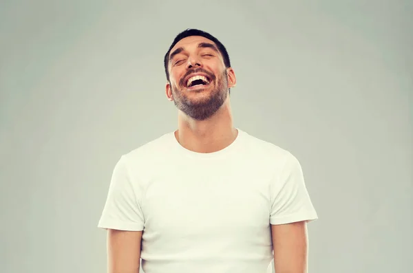 Lachen man over grijze achtergrond — Stockfoto