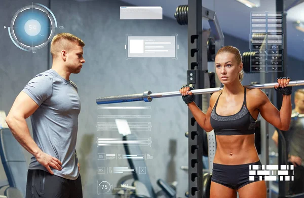 Homem e mulher com músculos de flexão barbell no ginásio — Fotografia de Stock