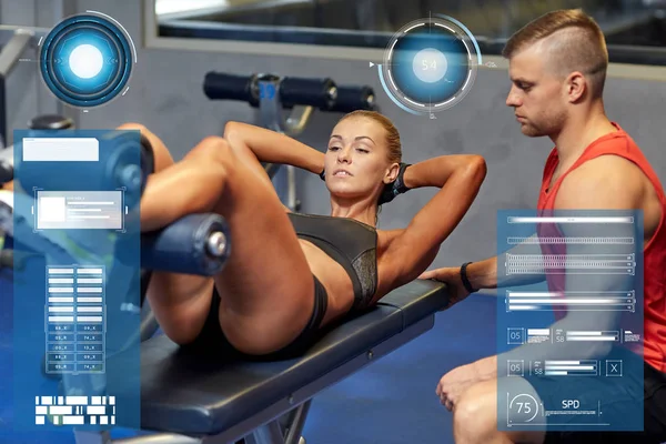 Mulher com personal trainer fazendo sit ups no ginásio — Fotografia de Stock