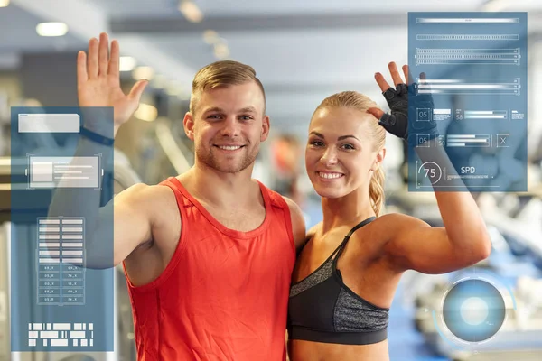 Smiling man and woman waving hands in gym — Stock Photo, Image