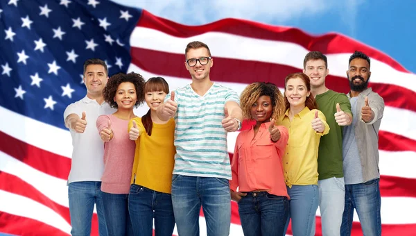 Happy people showing thumbs up over american flag — Stock Photo, Image